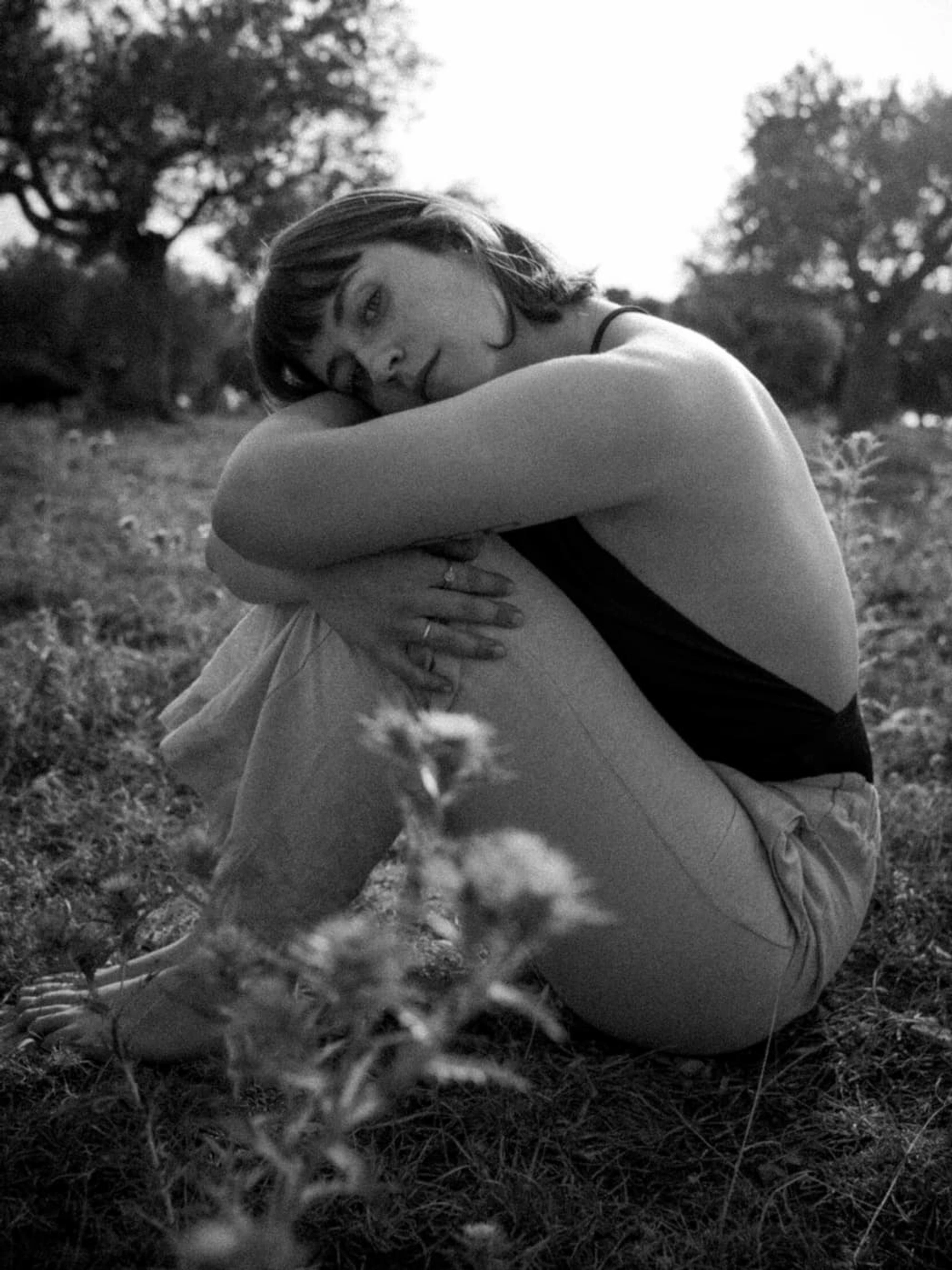 black and white portrait of a woman sitting on the ground