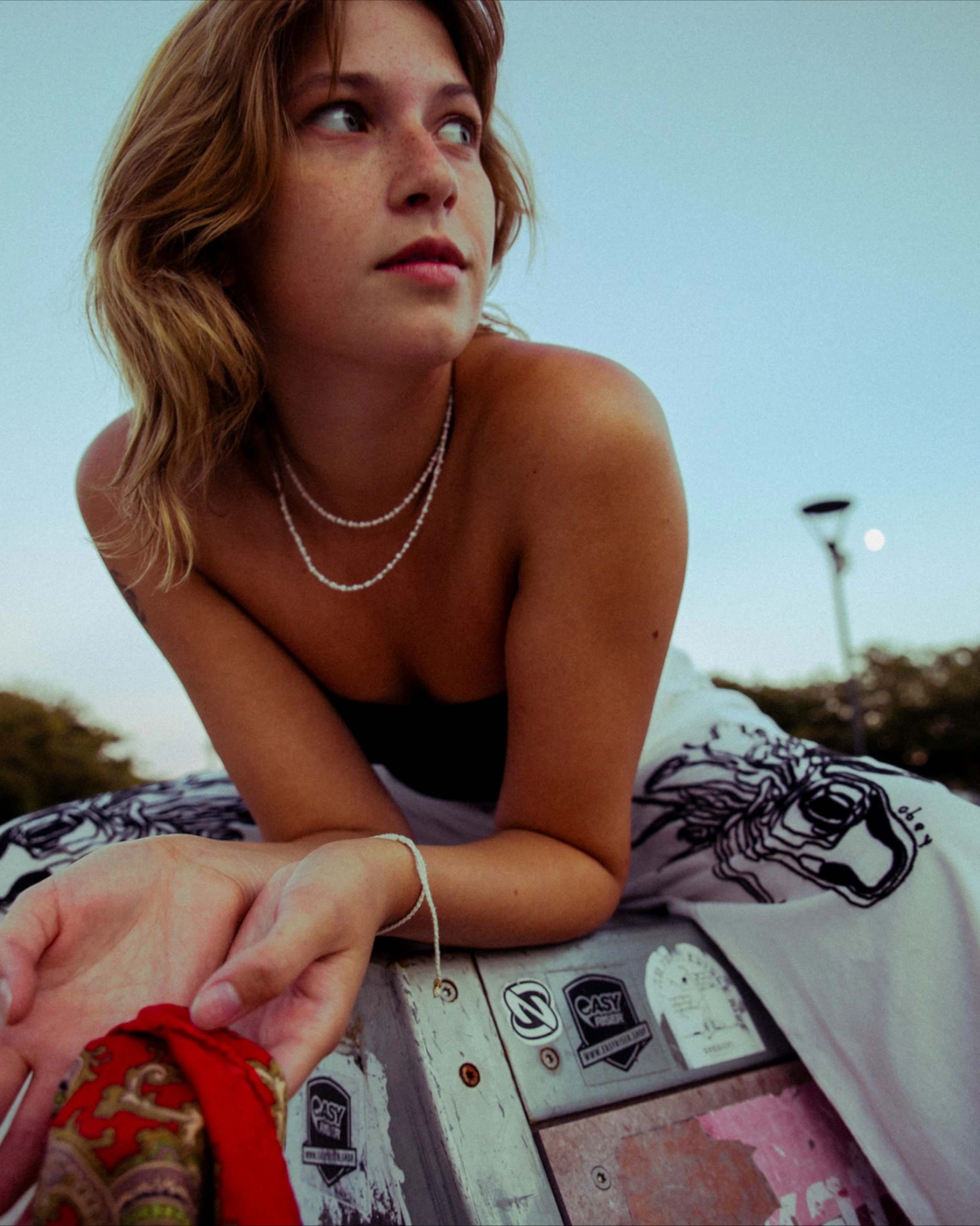 young woman sitting on a halpipe in a skate park