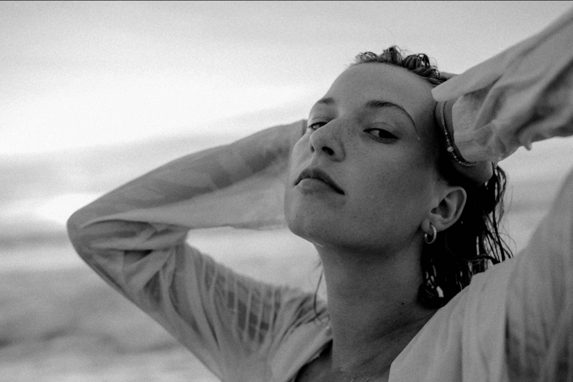 black and white portrait of a young woman in front of the sea