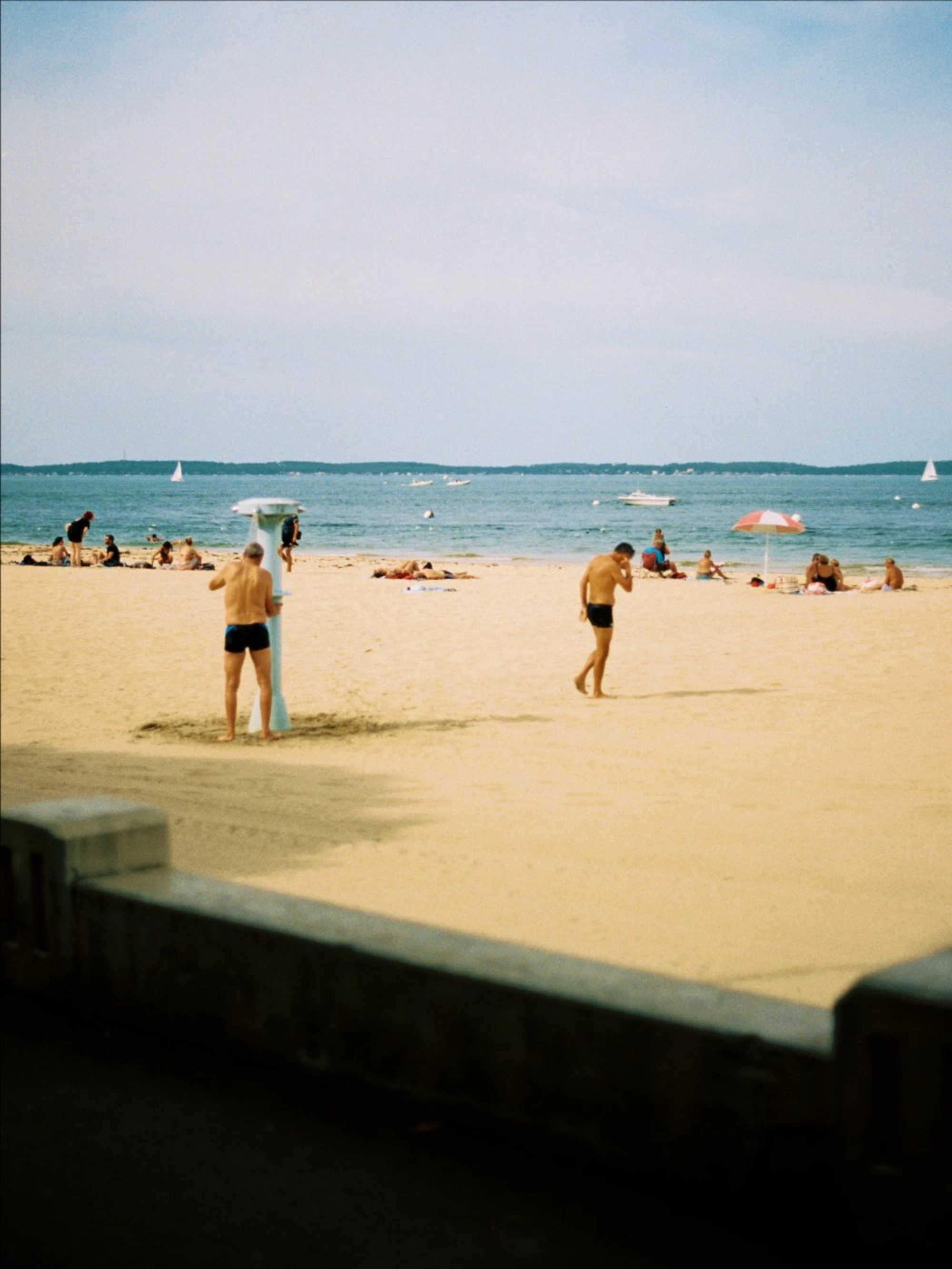 people walking and lying on the beach
